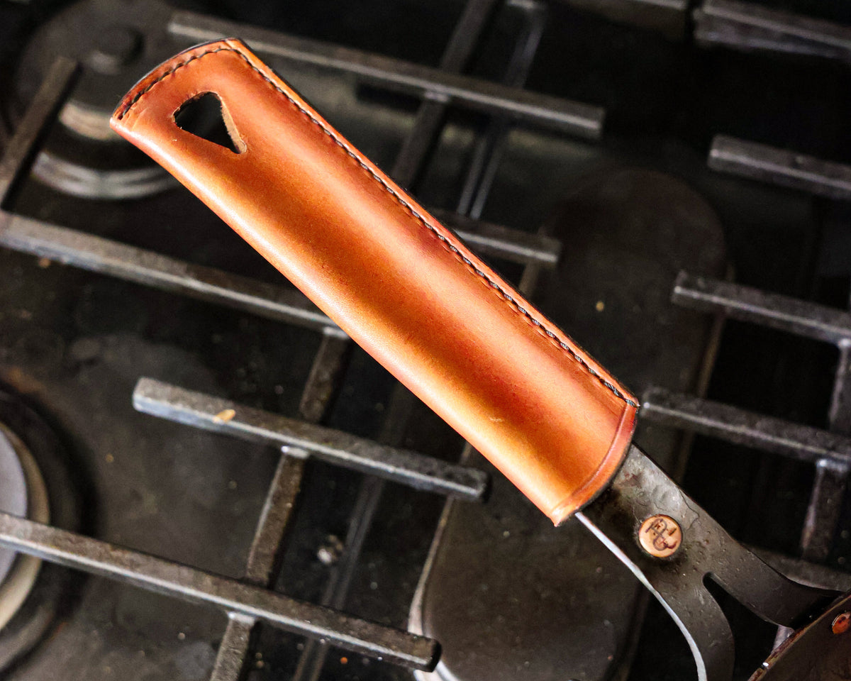 Close-up of the Leather Handle Cover on The Original's steel handle over a gas range