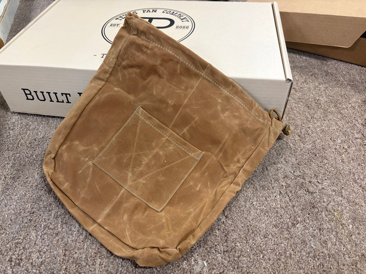 Empty Canvas Skillet Bag in tan waxed canvas showing the front patch pocket and cord lock