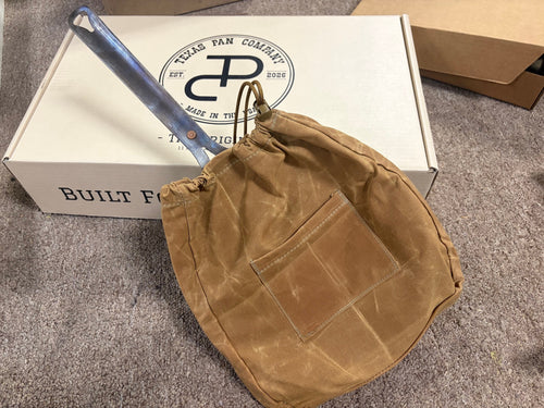 The Original carbon steel skillet in the Canvas Skillet Bag, lying on a Texas Pan Company box