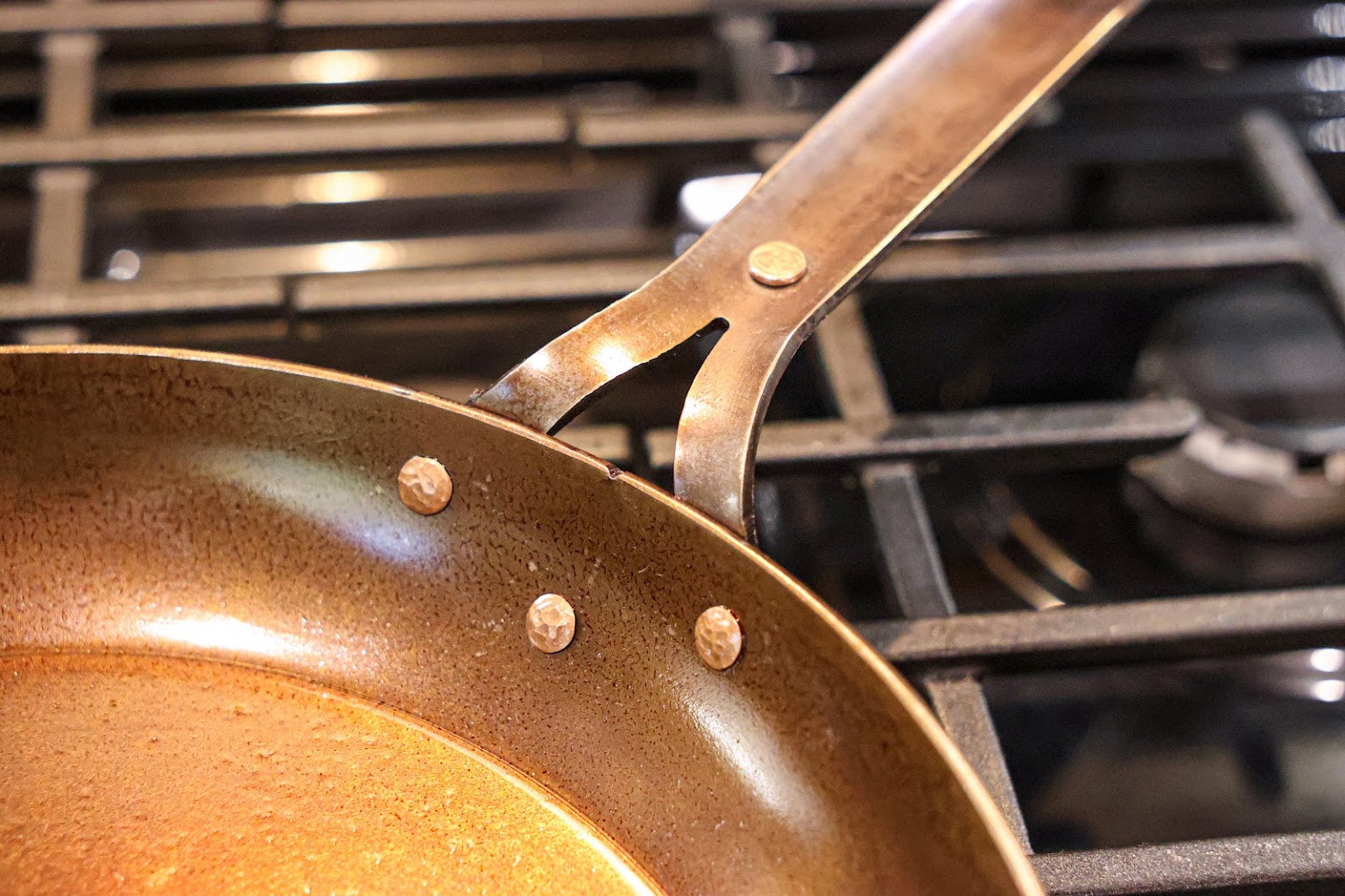Close-up of the three copper rivets joining the handle to the inside wall of the skillet